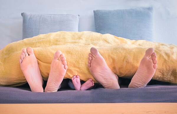 子育て中の夫婦と赤ちゃんの足